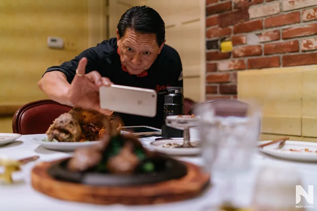 Chef Chu photographing a dish with his phone