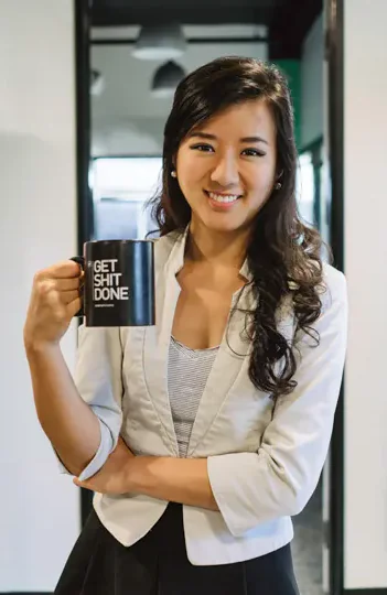 Nanxi Liu holding a mug beside Enplug displays